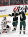 Chicago Blackhawks goaltender Jeff Glass , left, gives up a power play goal to Minnesota Wild's Mikko Koivu, right, of Finland, in the first period of
