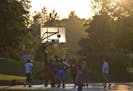 A groupf of men played basketball at dusk at Powderhorn Park in Minneapolis, Minn., during the hot weather on Tuesday, July 16, 2013.
