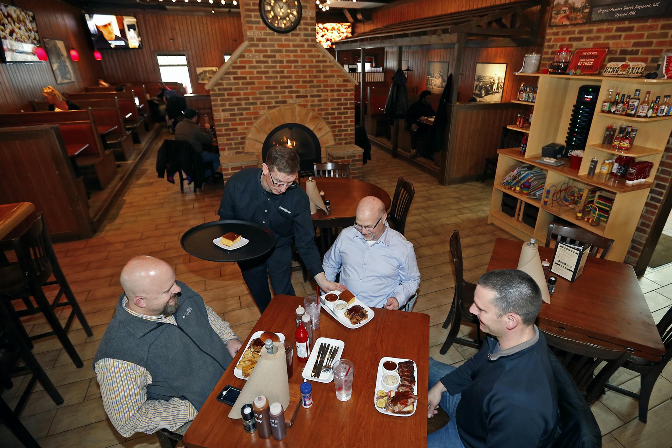 General Manager Darren Farley serves food to patrons at the newly remodeled Famous Dave's Legendary Pit Bar-B-Que restaurant on Wednesday, March 4, 2015, in Bolingbrook, Illinois, (AP Photo/Jeff Haynes) ORG XMIT: ILJH109