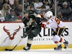 Minnesota Wild's David Jones (12) handles the puck against Calgary Flames' Oliver Kylington (58) during the second period of an NHL hockey game Saturd