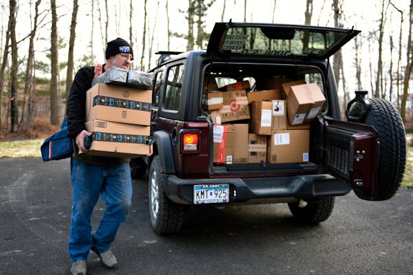 Mail carrier Dennis Nelson delivered Amazon packages to a home in remote northern Minnesota on Saturday. MUST CREDIT: Photos by Dan Koeck for The Wash