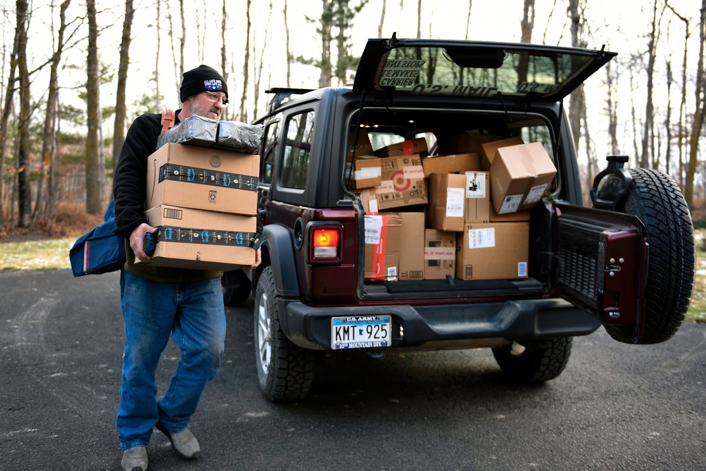 Mail carrier Dennis Nelson delivered Amazon packages to a home in remote northern Minnesota on Saturday. MUST CREDIT: Photos by Dan Koeck for The Washington Post