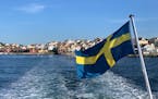 A Swedish flag flies behind a ferry departing Fiskebackskil, a Swedish island. Photo by Raphael Kadushin, special to the Star Tribune