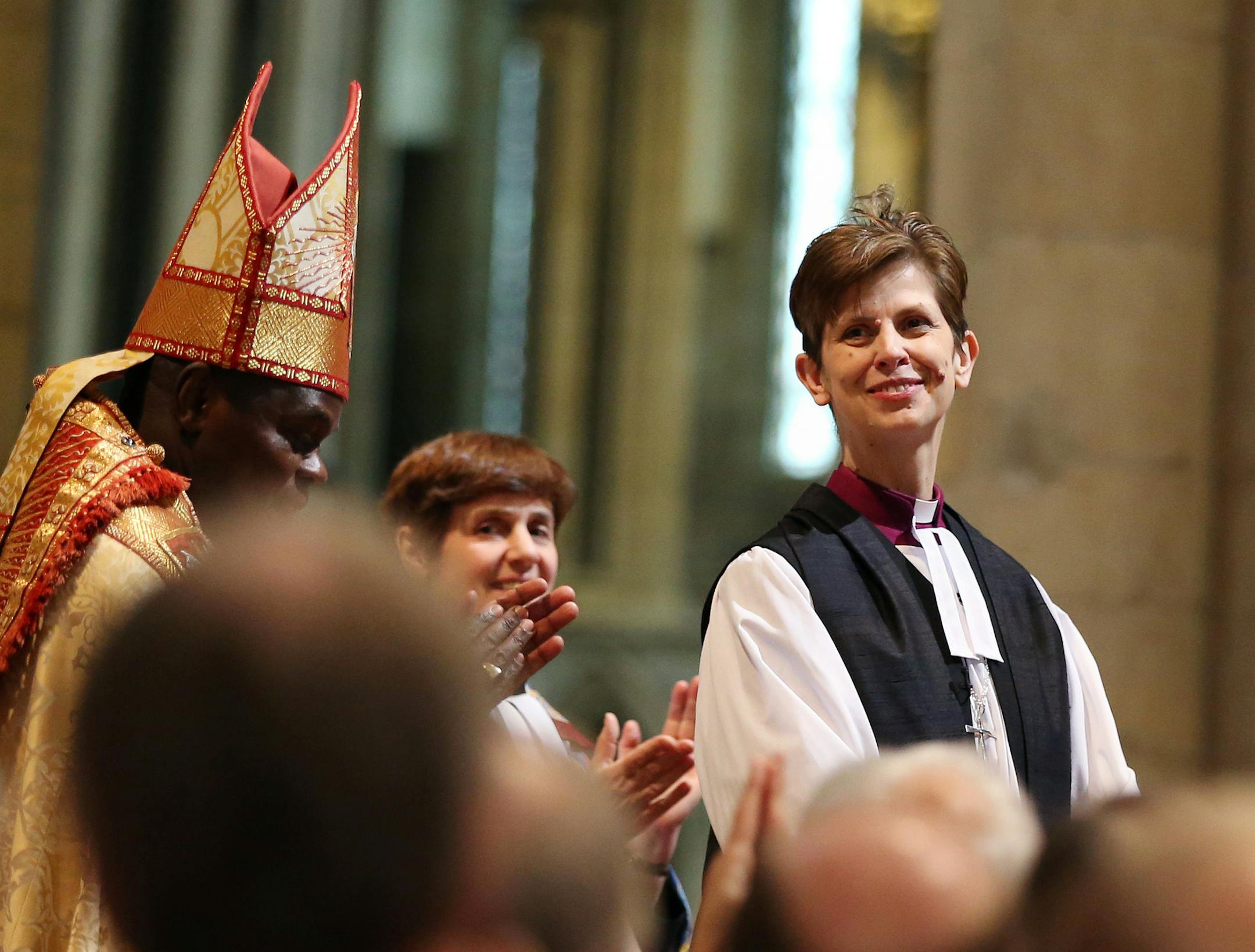 The Rev. Libby Lane smiles during her consecration as the eighth Bishop of Stockport, as Archbishop of York Dr John Sentamu, left, applauds at York Minster, England, Monday Jan. 26, 2015. Male domination in the leadership of the Church of England is coming to an end, as the 500-year-old institution consecrates its first female bishop. (AP Photo/PA, Lynne Cameron) UNITED KINGDOM OUT NO SALES NO ARCHIVE