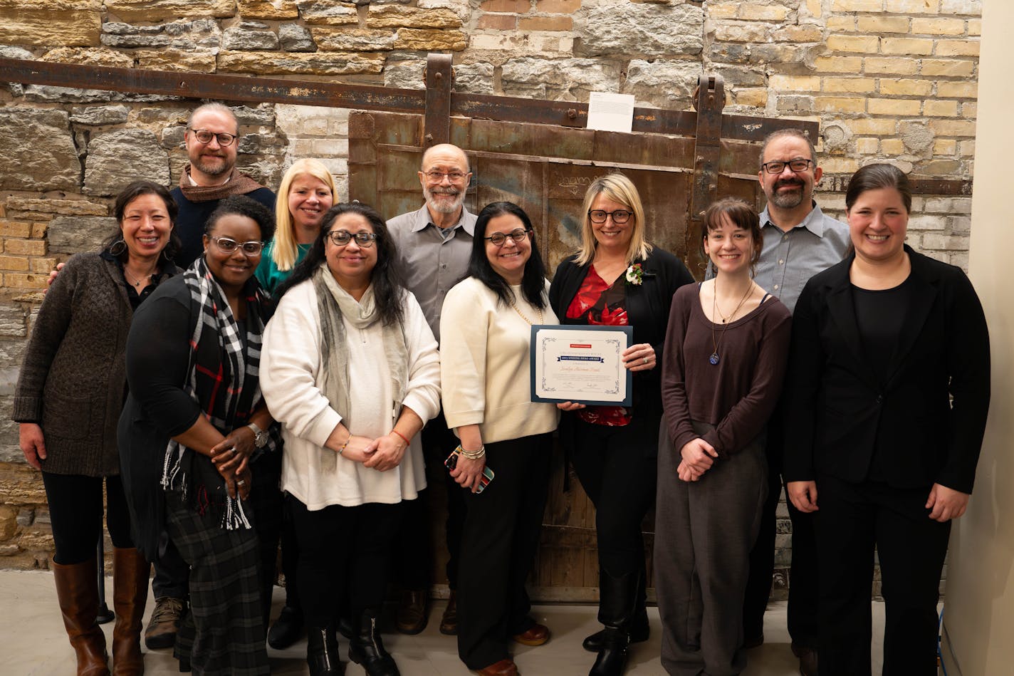 Jessalyn Akerman-Frank accepted a 2023 Virginia McKnight Binger Unsung Hero Award surrounded by friends and family, including her wife, Lys; Migdalia Rogers, who nominated her for the award; and her longtime friend and interpreter Tarra Grammenos.