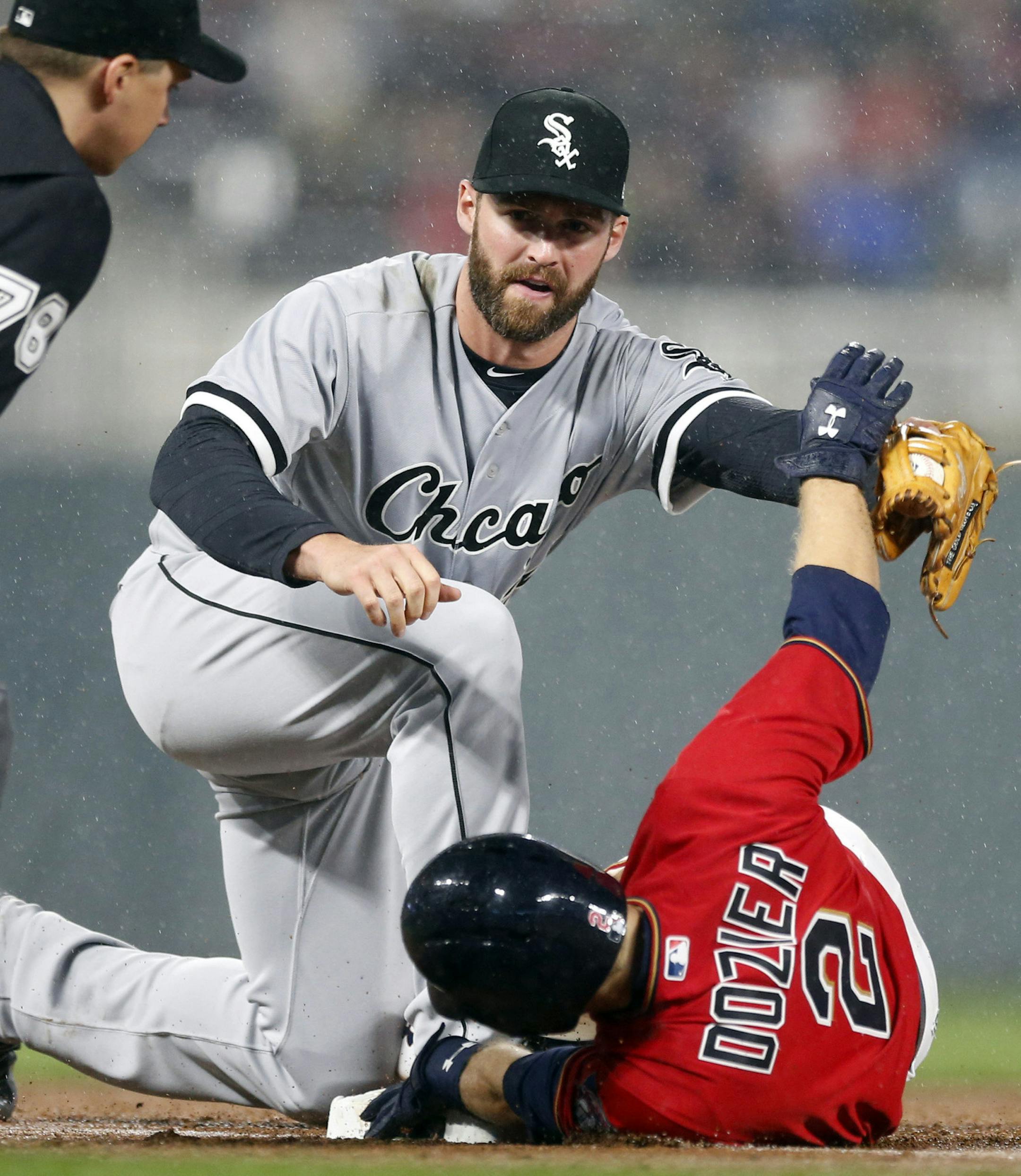 Minnesota Twins' Brian Dozier, right, is tagged out by Chicago White Sox third baseman Matt Davidson as he attempted to stretch a double into a triple during the fifth inning of a baseball game Friday, April 14, 2017, in Minneapolis. (AP Photo/Jim Mone)