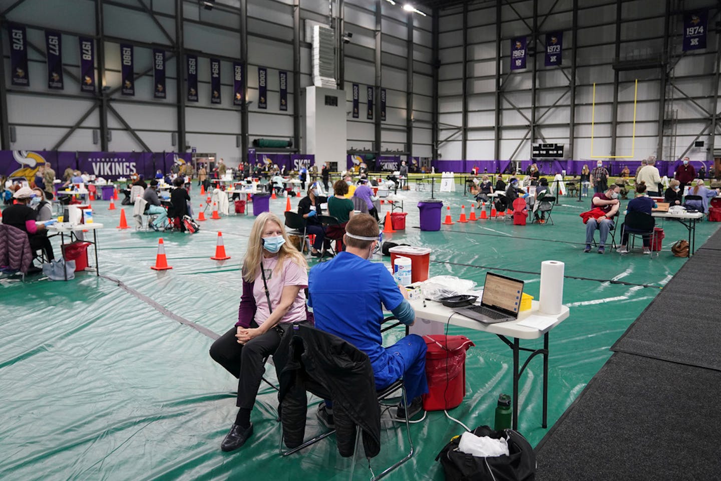 A woman sat waiting to be vaccinated at the Vikings Training Center that'd been converted into a site administering the newly available, single-dose, Johnson &amp; Johnson COVID-19 vaccine Friday, March 5, 2021, in Eagan, Minn. (Anthony Souffle/Star Tribune via AP)