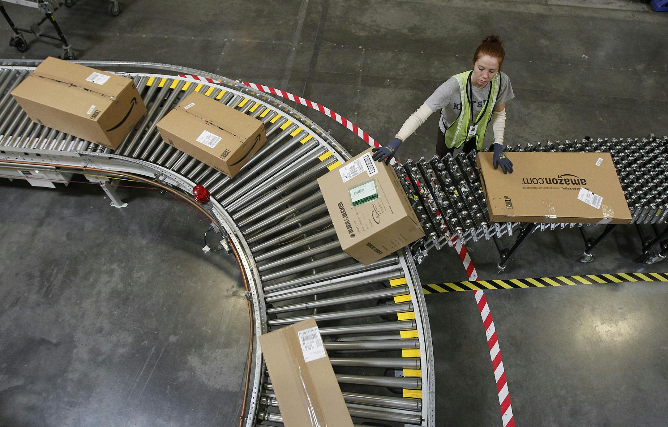 FILE - In this Nov. 11, 2010 file photo, Katherine Braun sorts packages toward the right shipping area at an Amazon.com fulfillment center in Goodyear, Ariz. Amazon.com said Tuesday, Oct. 1, 2013, it is hiring 70,000 full-time seasonal workers around the U.S. to fill orders during the holiday season. (AP Photo/Ross D. Franklin, file)