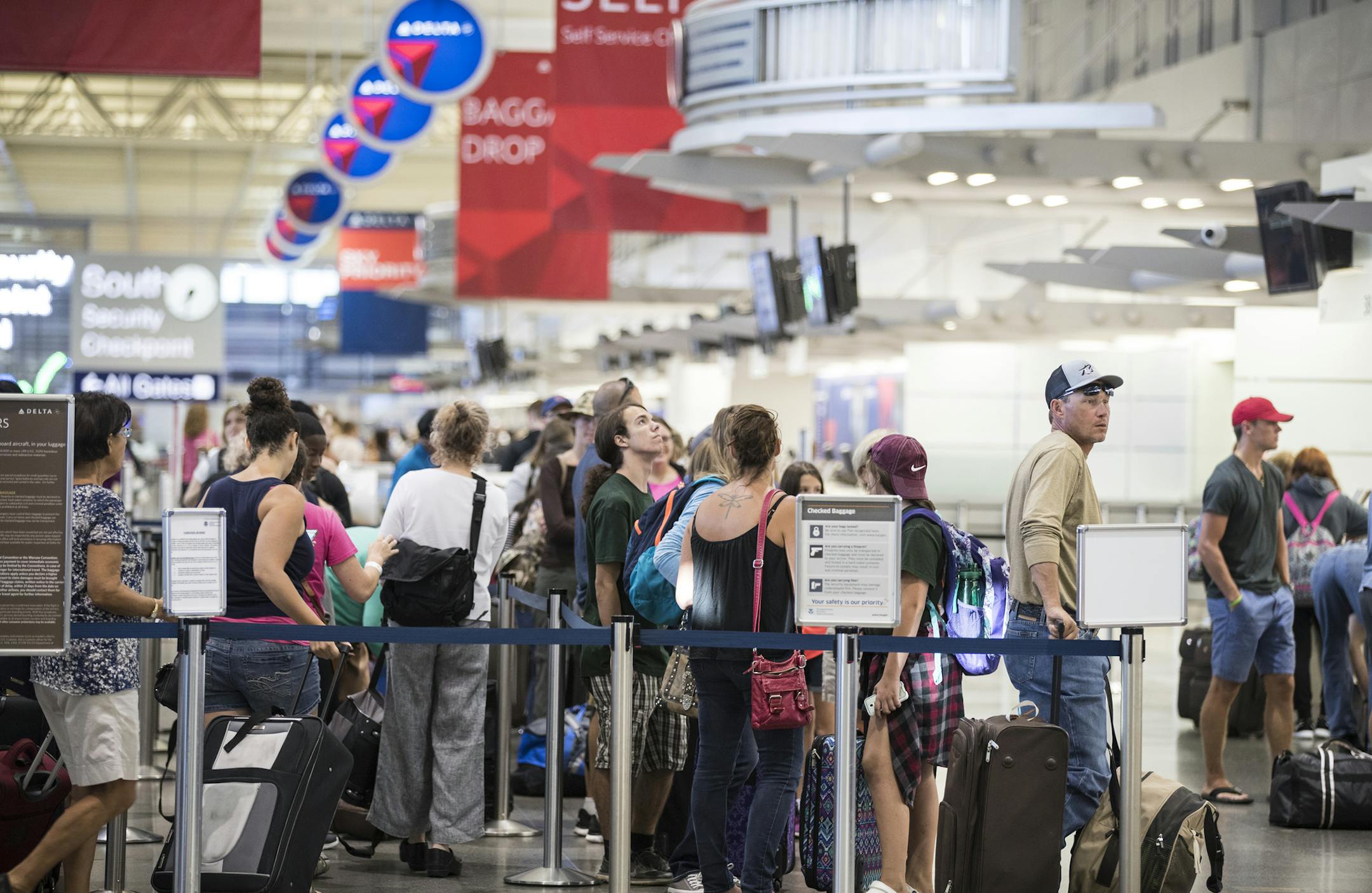 People wait in line at the check in area for Delta at MSP Airport. ] (Leila Navidi/Star Tribune) leila.navidi@startribune.com BACKGROUND INFORMATION: At Minneapolis - St. Paul International Airport on Monday, August 8, 2016. A power outage in Atlanta, which began at approximately 2:30 AM EST impacted Delta computer systems and operations worldwide, resulting in massive flight delays and cancellations.
