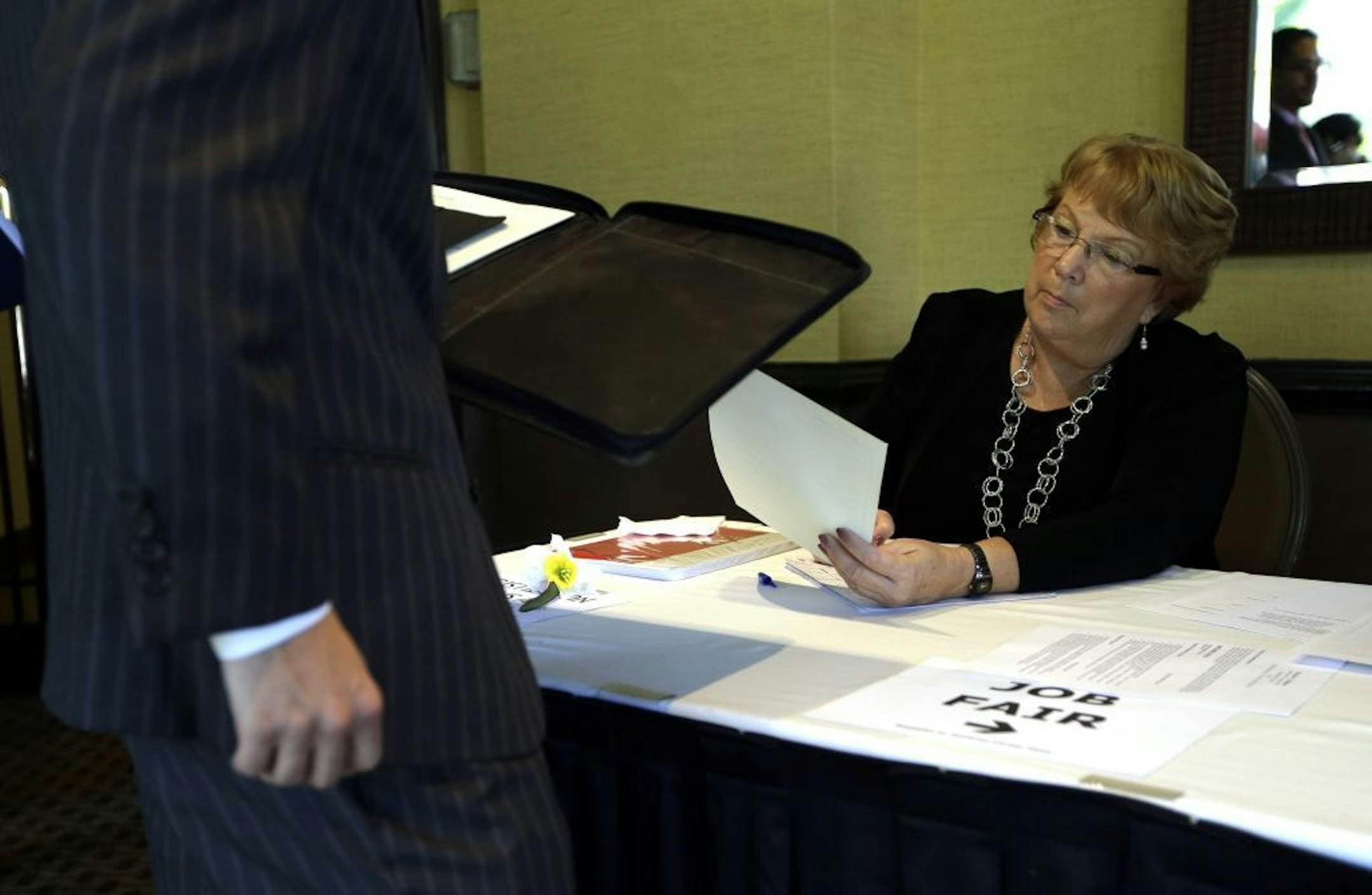 FILE-In this Sept. 17, 2012, file photo, Patti Maurer of Pompano Beach, Fla., right, registers a job seeker at a job fair held by National Career Fairs, in Fort Lauderdale, Fla. A private survey relased Wednesday, Oct. 3, 2012, shows that U.S. businesses hired fewer workers in September than August, a sign that slow growth may be holding back hiring. Payroll processor ADP said Wednesday that companies added 162,000 jobs last month. That�s below August�s total of 189,000, which was revised lower.