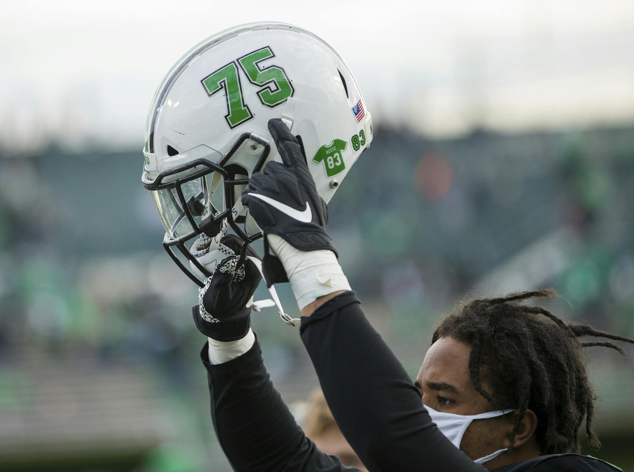 A Marshall player points to a "75" decal after the team's win over Middle Tennessee during an NCAA college football game Saturday, Nov. 14, 2020, in Huntington, W.Va. (Sholten Singer/The Herald-Dispatch via AP)