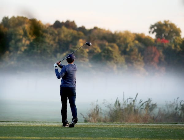 A golfer, who wished not to be identified, hits a tee shot on Hiawatha Golf Course, which was consumed by fog near dawn Tuesday in Minneapolis. ]