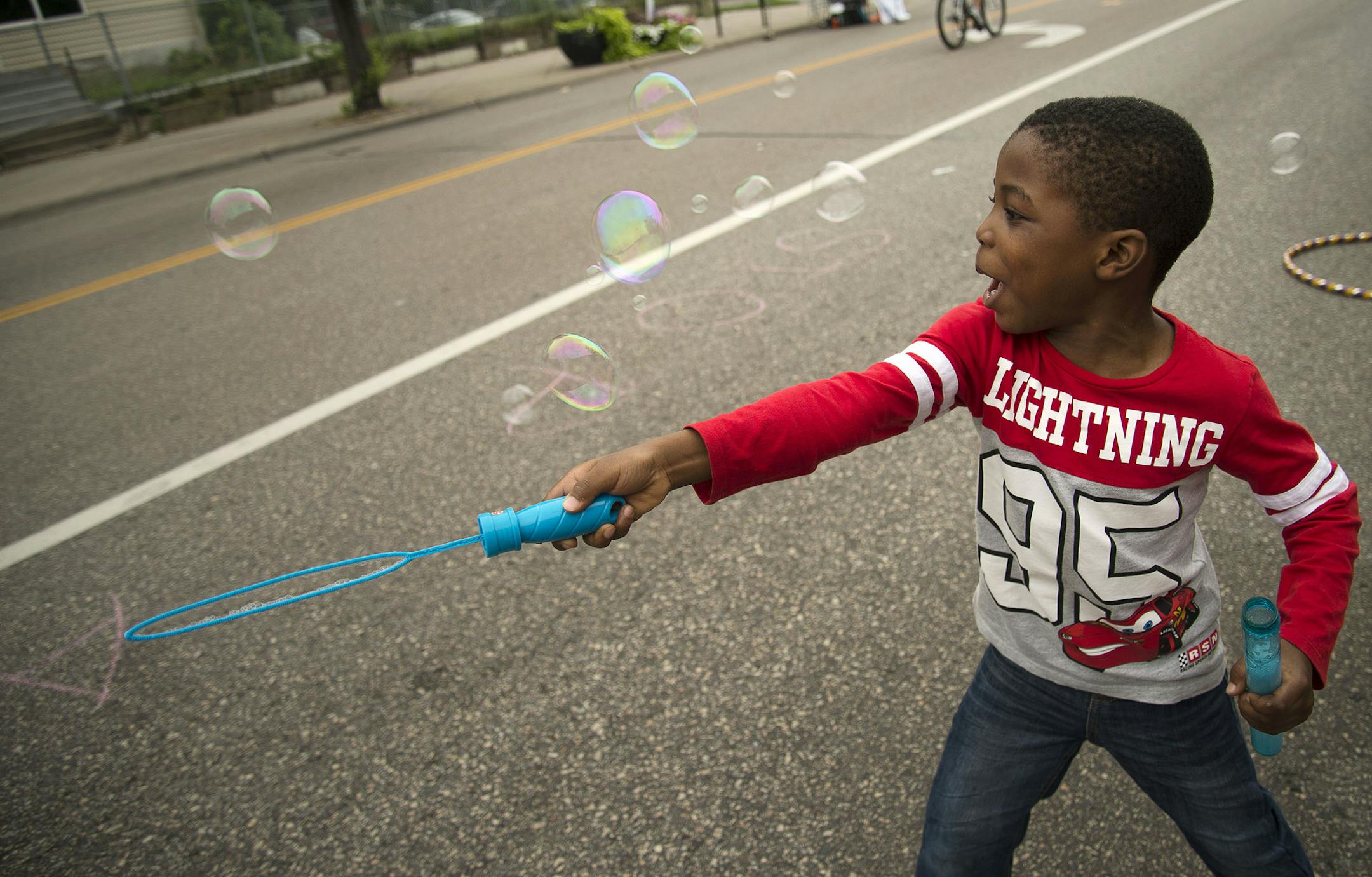 Abud Qodiri Bolarinwa, 5, of Minneapolis, played with bubbles at the “sPARKit” pop-up park during Open Streets Minneapolis on E. Franklin Av. on Sunday.