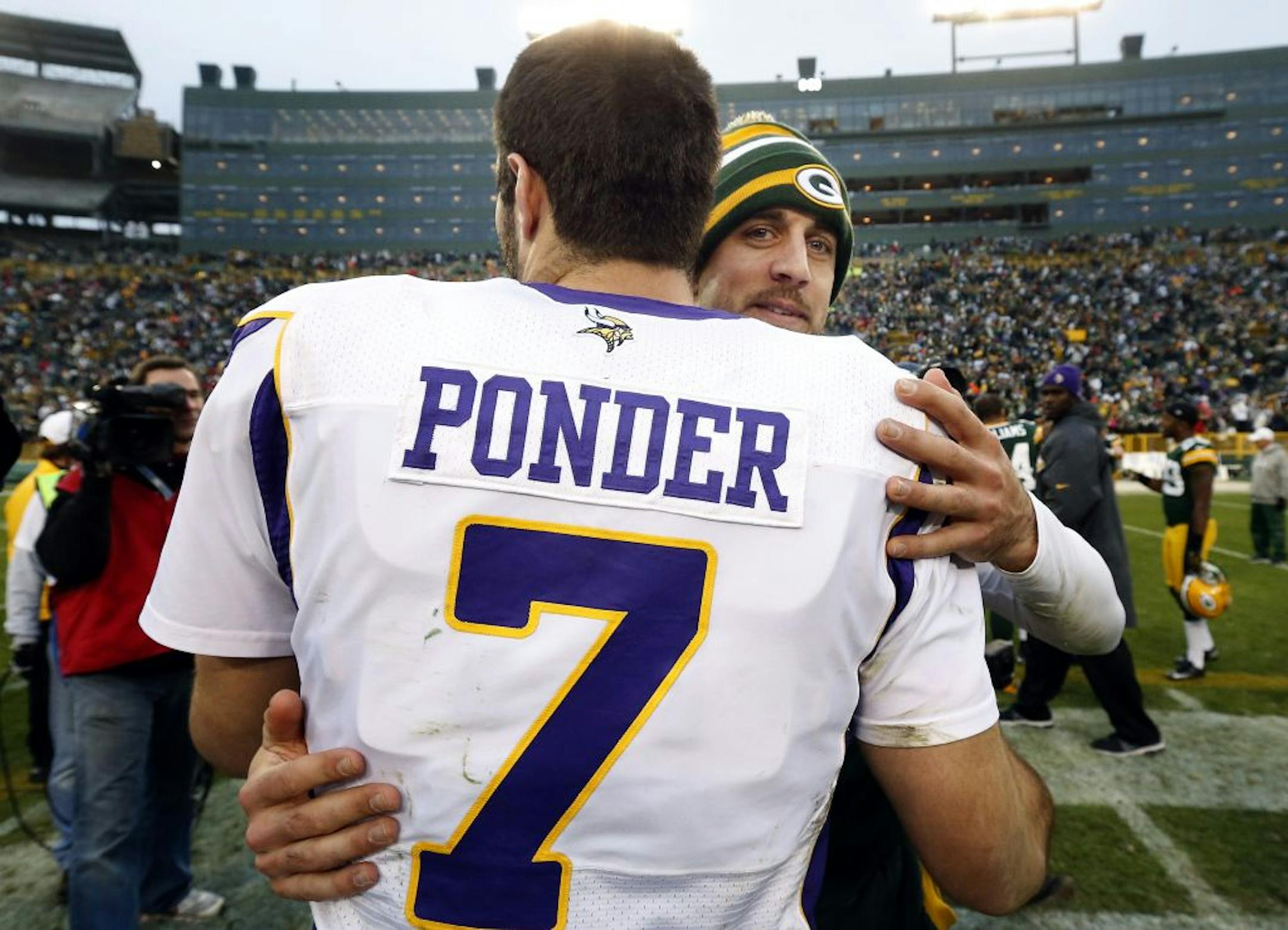 Green Bay quarterback Aaron Rodgers (12) hugged Vikings QB Christian Ponder (7) at the end of the game. Green Bay beat Minnesota by a final score of 23-14.