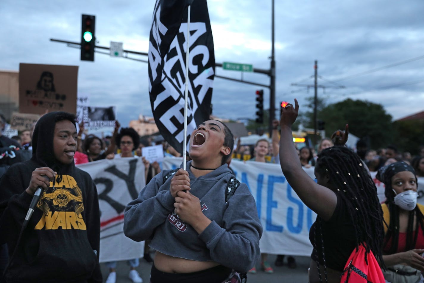 Supporters of Philando Castile held signs as they marched along University Ave. in St. Paul, leaving a vigil at the State Capitol.