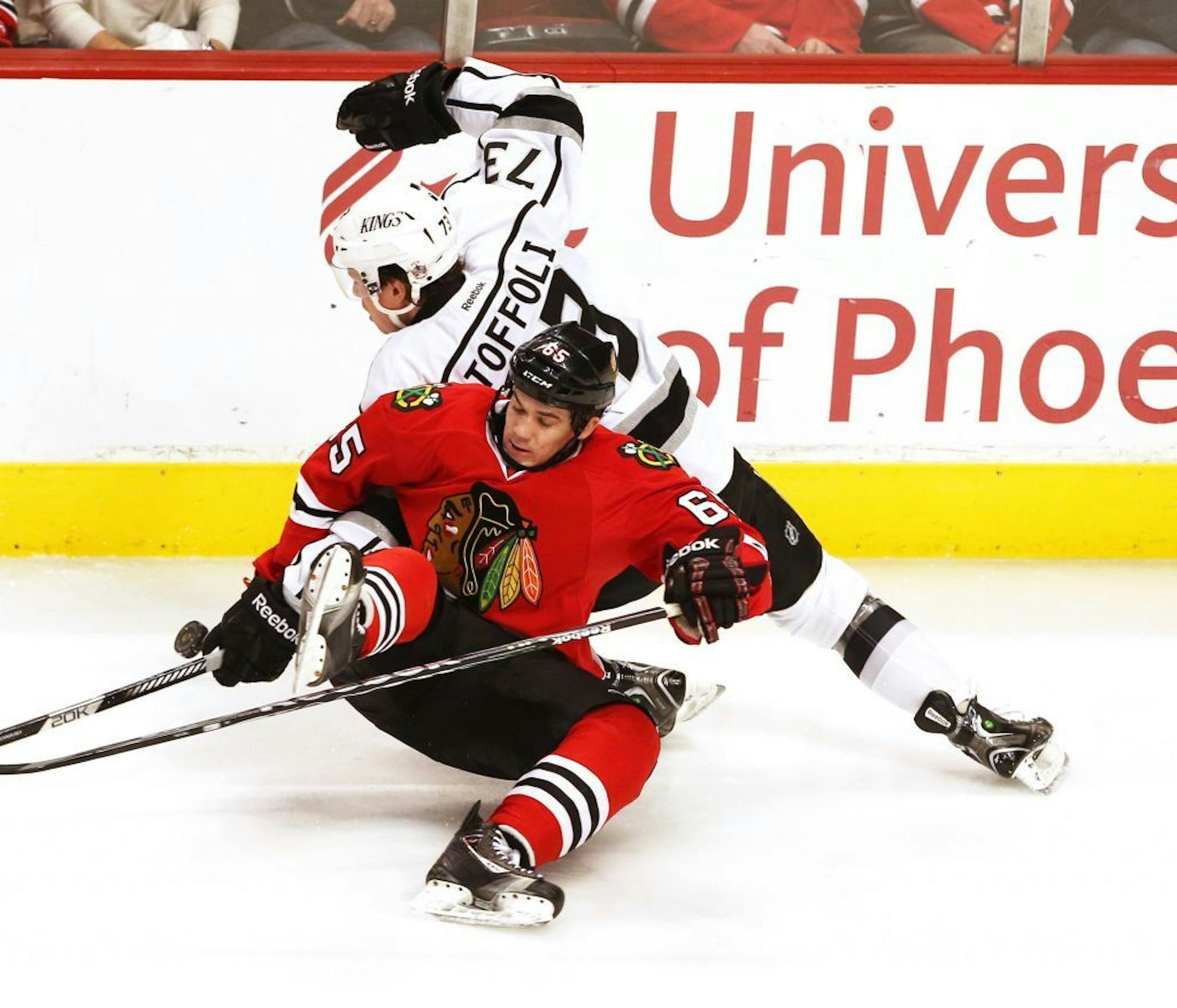 Chicago Blackhawks center Andrew Shaw (65) hits the ice as he goes for the puck against Los Angeles Kings center Tyler Toffoli (73) during the second period at the United Center in Chicago, Illinois on Monday, March 25, 2013.