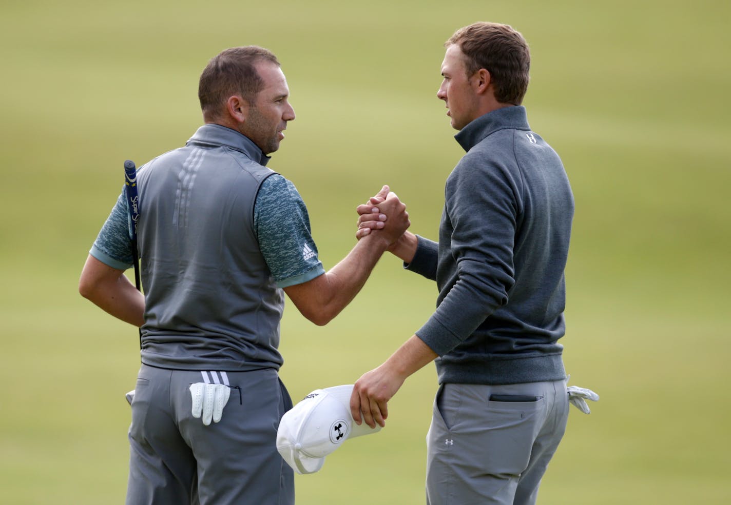 Jordan Spieth, right, and Sergio Garcia shook hands on the 18th green after completing the third round of the British Open on Sunday. Spieth, who is trying to win the third leg of the Grand Slam, is one shot off the lead going into Monday's final round.