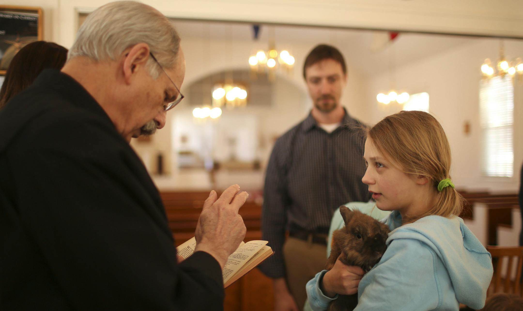 The Anglican Church of St. Dunstan in St. Louis Park held A Festival of Narnia Sunday afternoon, March 2, 2014. Events ranged from presentations on C.S. Lewis' association with Christianity, for grownups, to dogsled rides, for kids, to a Blessing of the Animals, for pets. Abby Sickler, 11, held her rabbit, Buddy, as he was blessed by The Rev. Fr. Paul Kolisch, Interim Recor at The Anglican Church of St. Dunstan Sunday afternoon. At rear was her dad, Brad Sickler, who gave a talk on C.S. Lewis ea