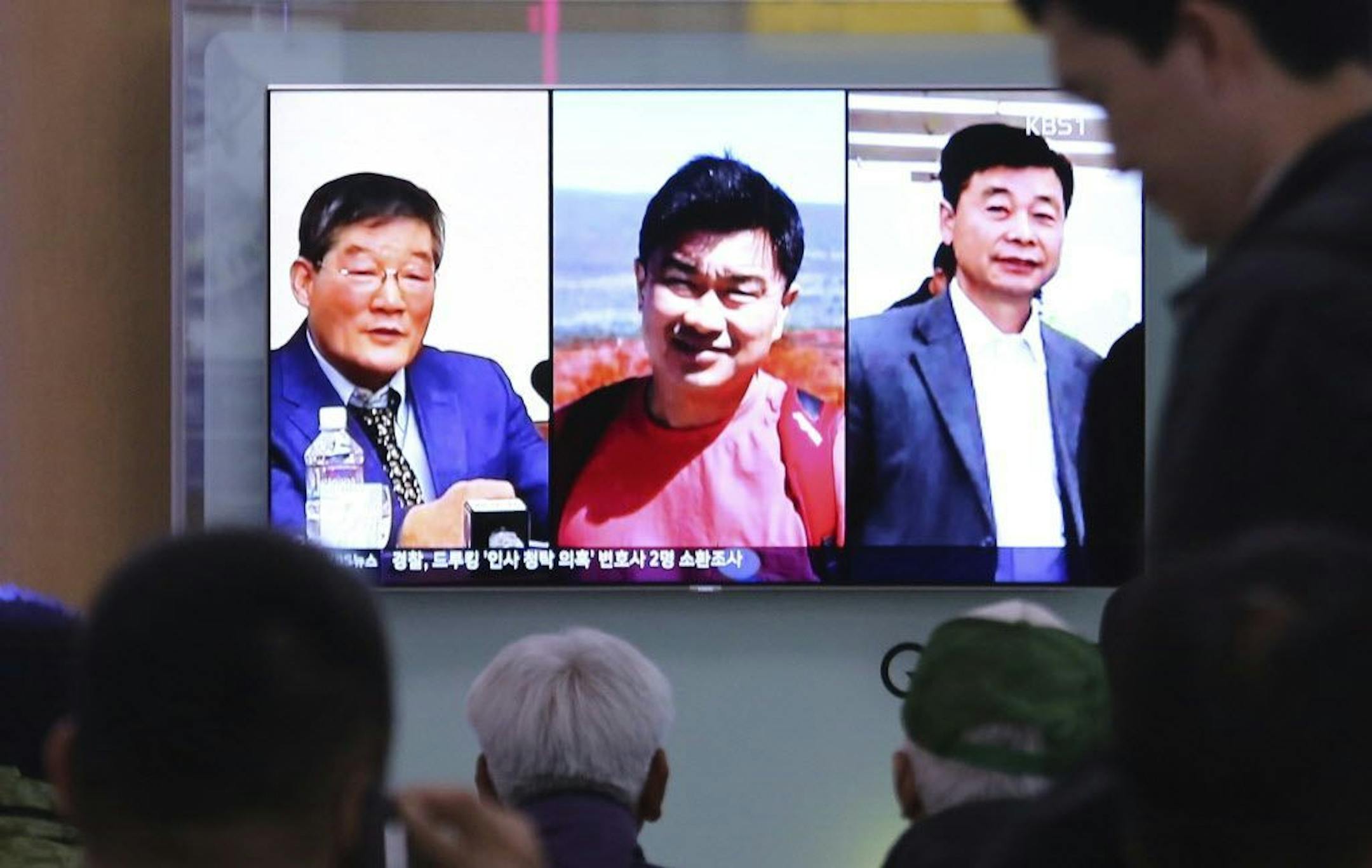 People at the Seoul Railway Station in Seoul, South Korea, watch a TV news report showing the three Americans, Kim Dong Chul, left, Tony Kim and Kim Hak Song, right, who had been detained in North Korea.
