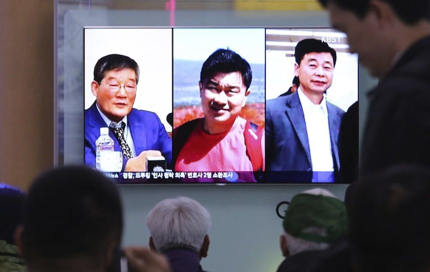 People at the Seoul Railway Station in Seoul, South Korea, watch a TV news report showing the three Americans, Kim Dong Chul, left, Tony Kim and Kim Hak Song, right, who had been detained in North Korea.