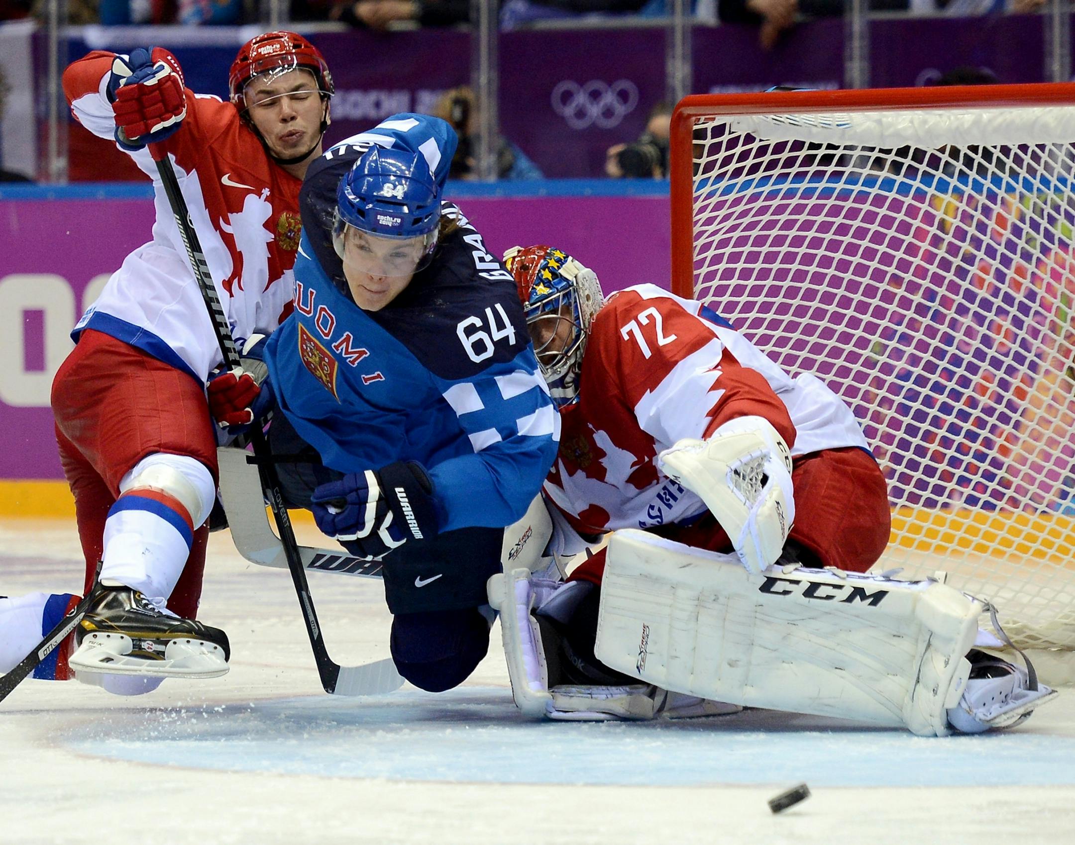 Finland forward Mikael Granlund (64) tries to make a play on the puck between Russia defenseman Alexei Emelin (74), left, and Russia goalie Sergei Bobrovsky (72) during the third period of a Winter Olympics quarterfinal at the Bolshoy Ice Dome in Sochi, Russia, Wednesday, Feb. 19, 2014. Finland defeated Russia, 3-1.