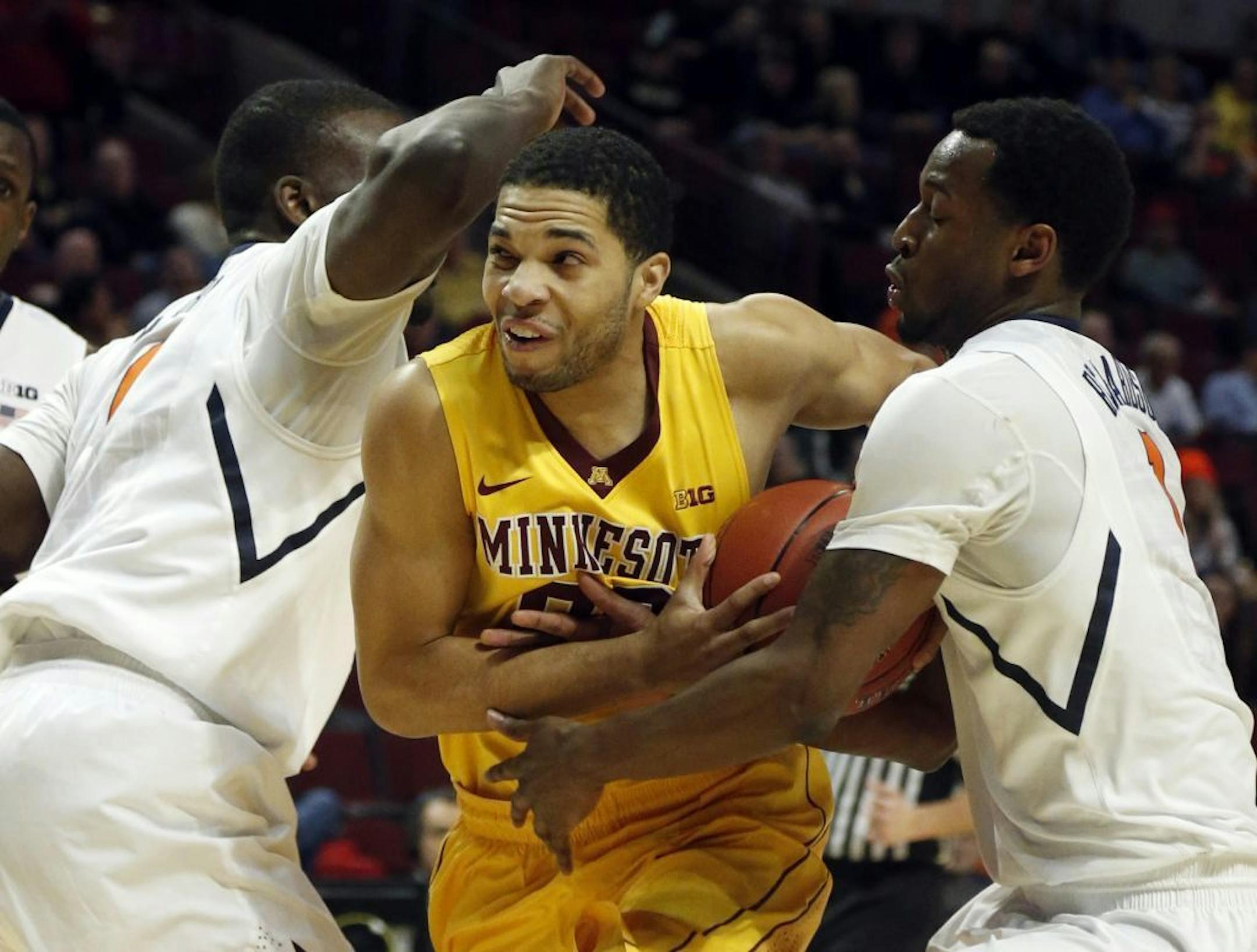 Minnesota's Julian Welch drives between Illinois' D.J. Richardson, right, and Sam McLaurin during the first half of an NCAA college basketball game at the Big Ten tournament Thursday, March 14, 2013, in Chicago.