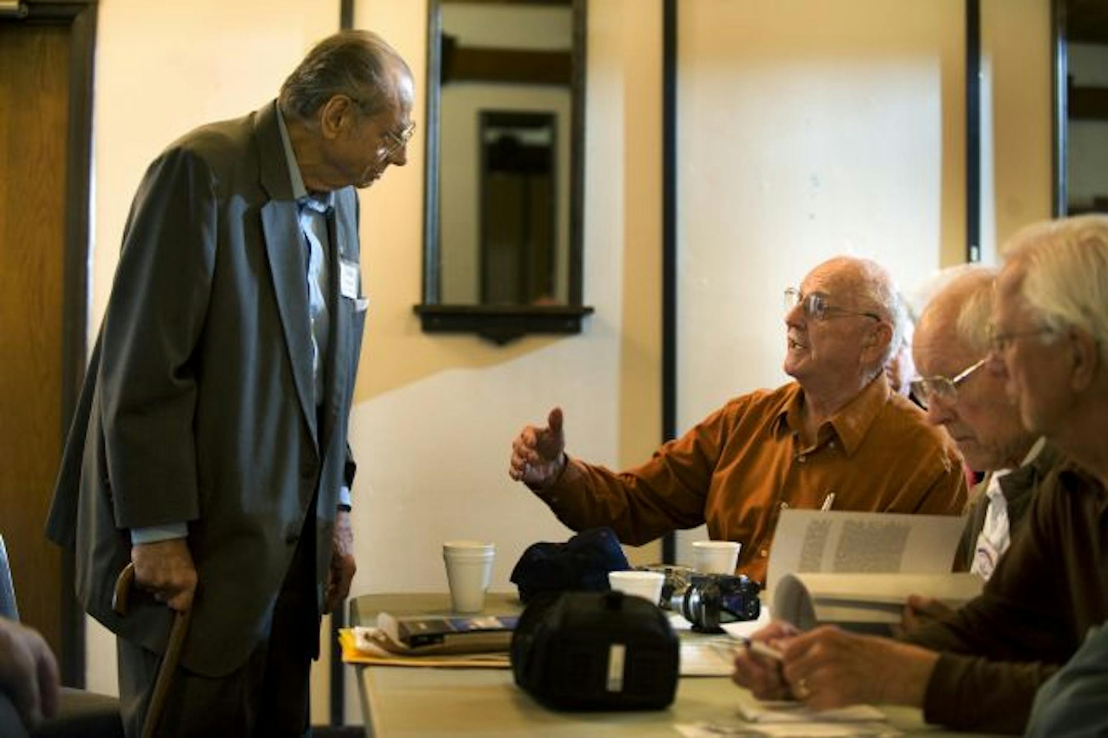 Michael Boosalis, left, and William Henry shared a story during a monthly gathering of Merchant Mariners at the Richfield American Legion. "You can't believe the stuff we hauled overseas," Boosalis said.