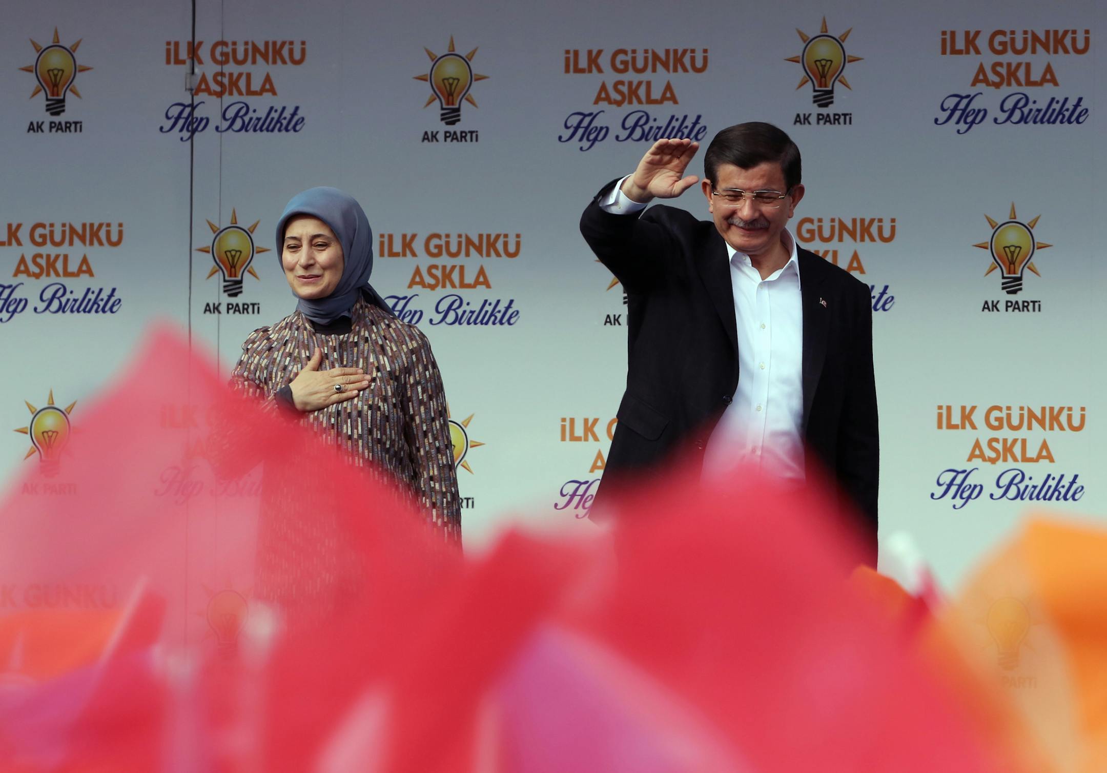 Turkish Prime Minister Ahmet Davutoglu and his wife Sare Davutoglu salute cheering supporters during a rally of his Justice and Development Party, or AKP, in Ankara, Turkey, Saturday, Oct. 31, 2015. Turkish political parties are making their closing appeals ahead of Sunday’s crucial general election parliamentary vote. (AP Photo/Burhan Ozbilici)