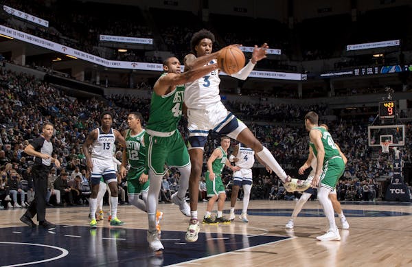 Al Horford (42) of the Celtics and Jaden McDaniels (3) of the Timberwolves fought for the ball during the Wolves’ victory Monday night at Target Cen