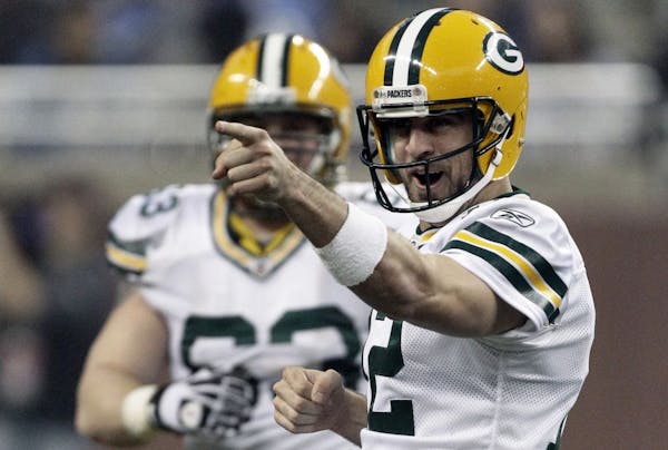 Packers quarterback Aaron Rodgers (right) celebrated after throwing a 65-yard touchdown pass to teammate James Jones in Green Bay's 27-15 victory over