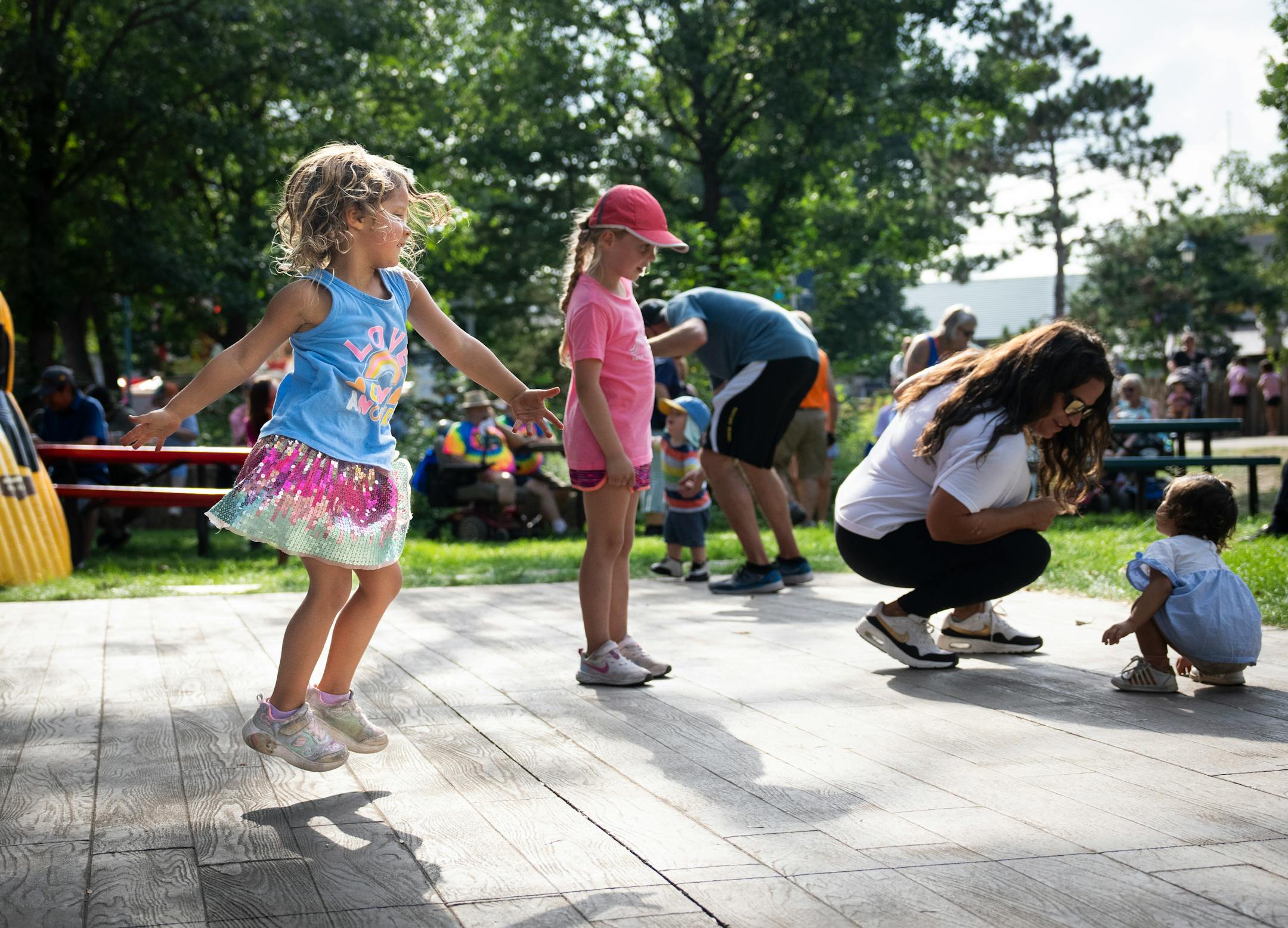 At left, Chloe Lange, on her fifth birthday, dances her heart out to the band Darlen and the Boys at teh DNR Stage on the first day of the Minnesota State Fair on Thursday, Aug. 24, 2023 in Falcon Heights, Minn.
