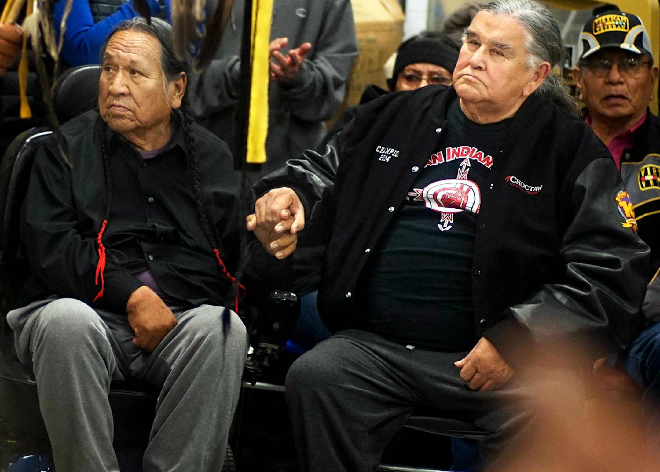 Leonard Crow Dog and Clyde Bellecourt, two of the founding members of the American Indian Movement, held hands during an orientation at Sitting Bull College in Fort Yates, N.D., where veterans arrived at Standing Rock Reservation.