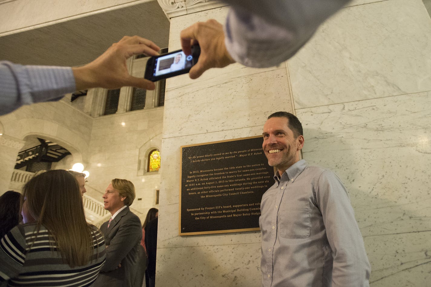 Joel Hoekstra takes a photo of his husband, Eric Jensen, next to a plaque unveiled on Thursday night commemorating the legalization of same sex marriage at Minneapolis City Hall. The two have been a couple for 18 years and were married last September. ] (Aaron Lavinsky | StarTribune) City and state officials will joined some of the state's first same-sex married couples at Minneapolis City Hall to unveil a new plaque commemorating the occasion. Attendees included former Mayor R.T. Rybak, Mayor B