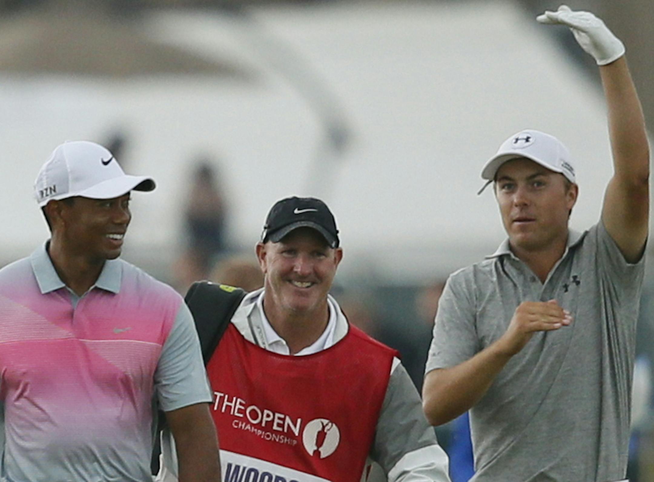 Tiger Woods of the US, center, and Jordan Spieth of the US, right, talk together as they walk along the 18th fairway with during the third day of the British Open Golf championship at the Royal Liverpool golf club, Hoylake, England, Saturday July 19, 2014. (AP Photo/Alastair Grant)