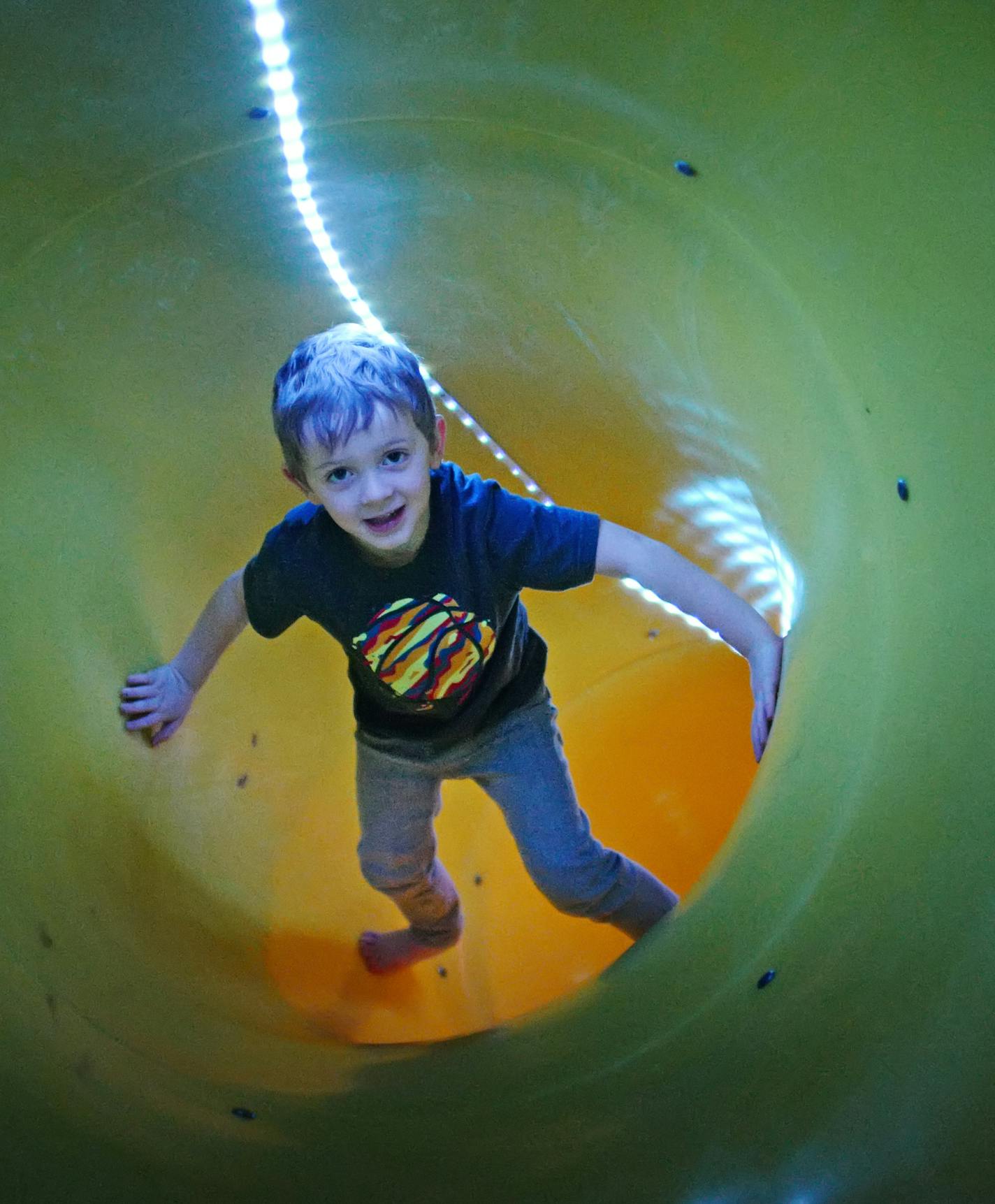 Leo Kuhl, with his friend Elliot Budziak, play on an indoor tube slide that descends from the mudroom to the basement, built by his dad, Steve Kuhl. Leo&#x2019;s sister, Charlie Kuhl, watches from a second-floor secret door.