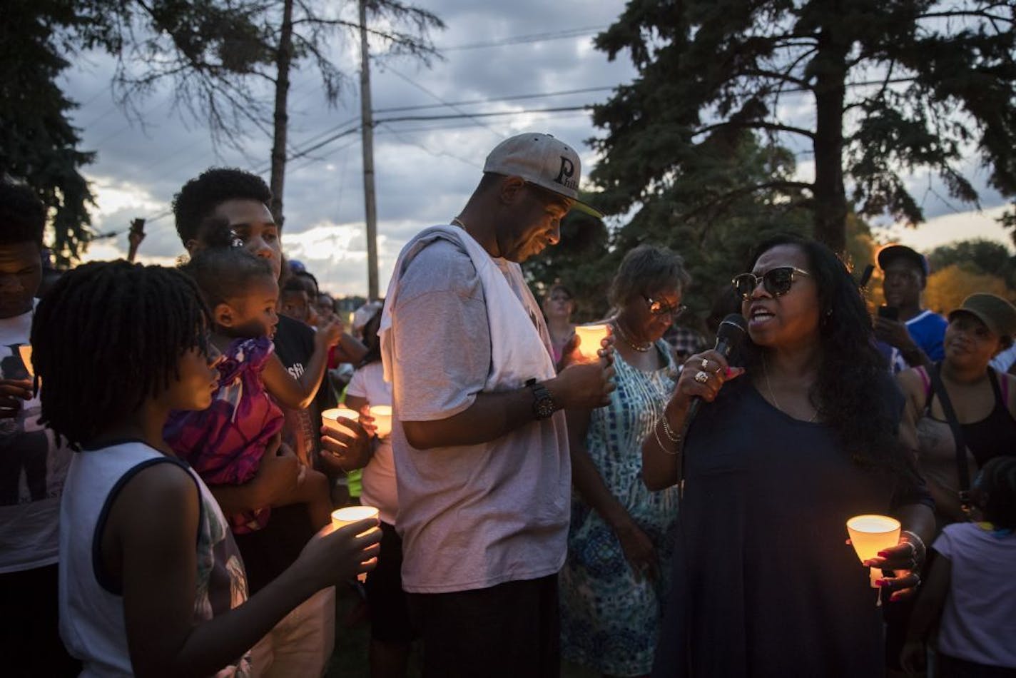 At right, Valerie Castile, the mother of Philando Castile, spoke during a candlelight vigil Thursday held in Falcon Heights where Philando was shot one year earlier by officer Jeronimo Yanez. Also pictured is Castile's friend John Thompson, center, and cousin Isaiah Johnson holding his niece London Amor.