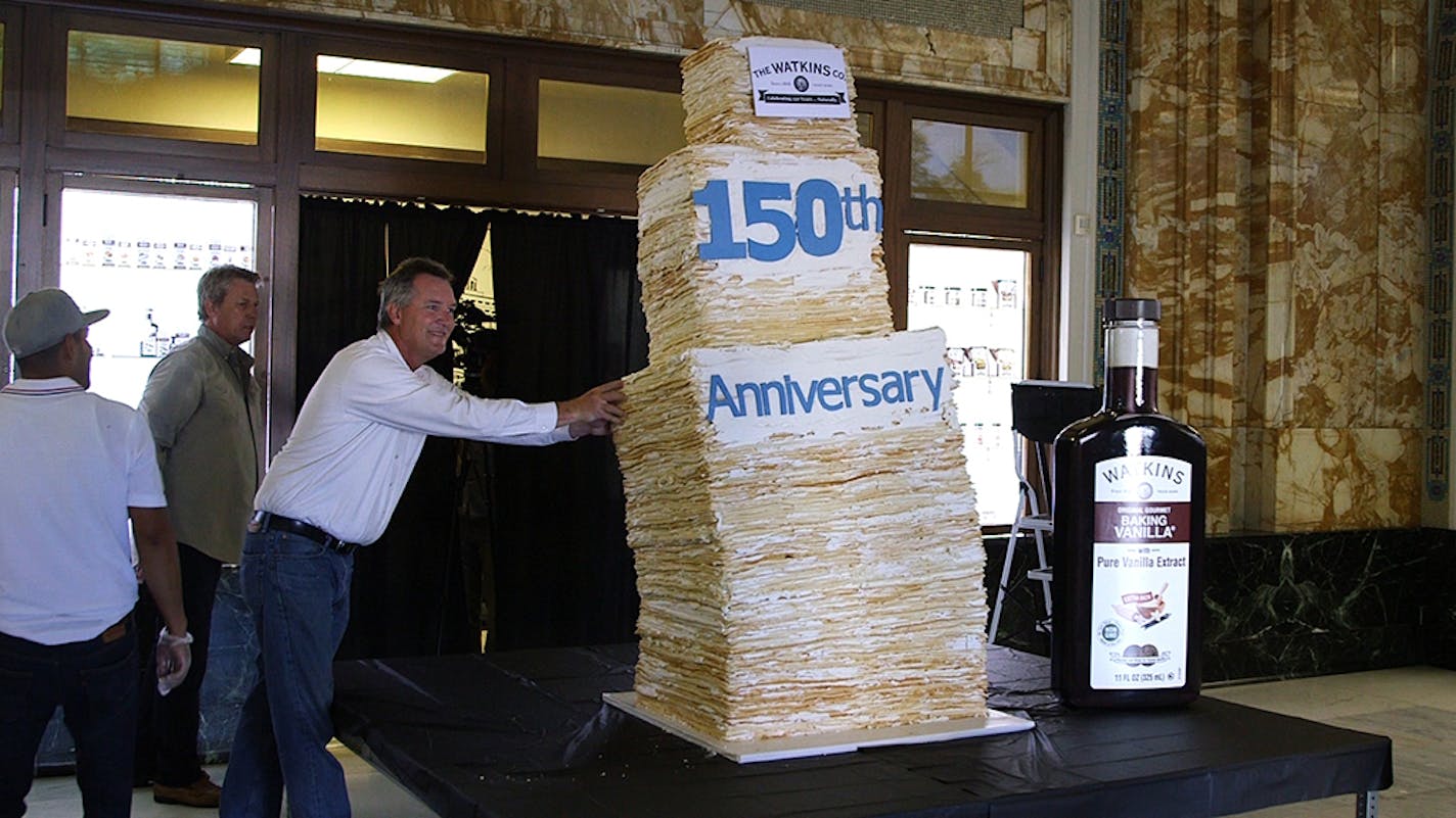 Hands at the ready, Wuollet Bakery's Doug Wuollet watched his 26-layer cake lean precipitously Friday in Winona, Minn. The cake held it together long enough (60 seconds) to be certified as a world record.