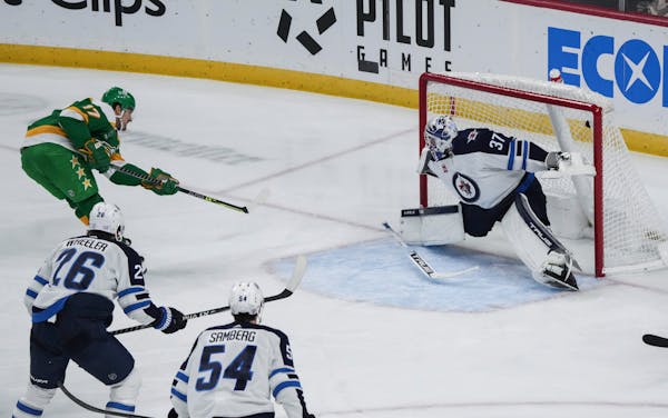 Marcus Foligno of the Wild scored against Jets goalie Connor Hellebuyck on Nov. 23 at Xcel Energy Center.
