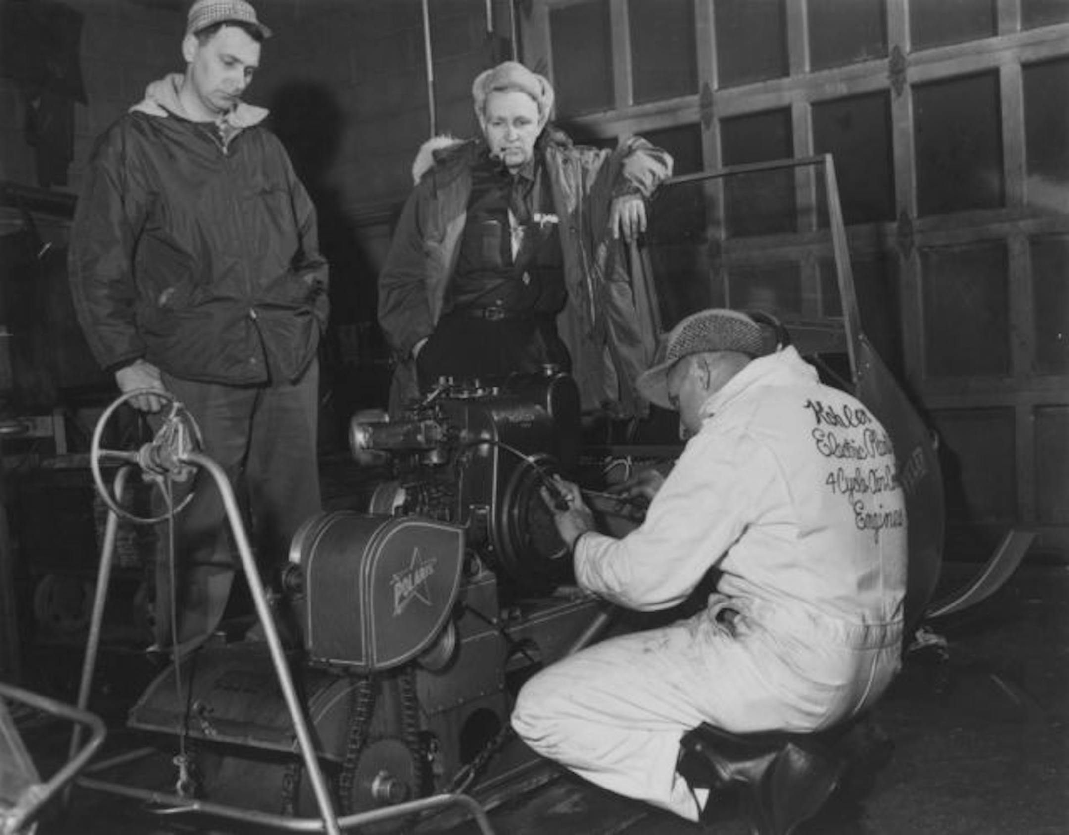 Allan Hetteen, Edgar Hetteen, center, and a snowmobile engine mechanic in the Roseau garage before the 1960 Alaska trip.