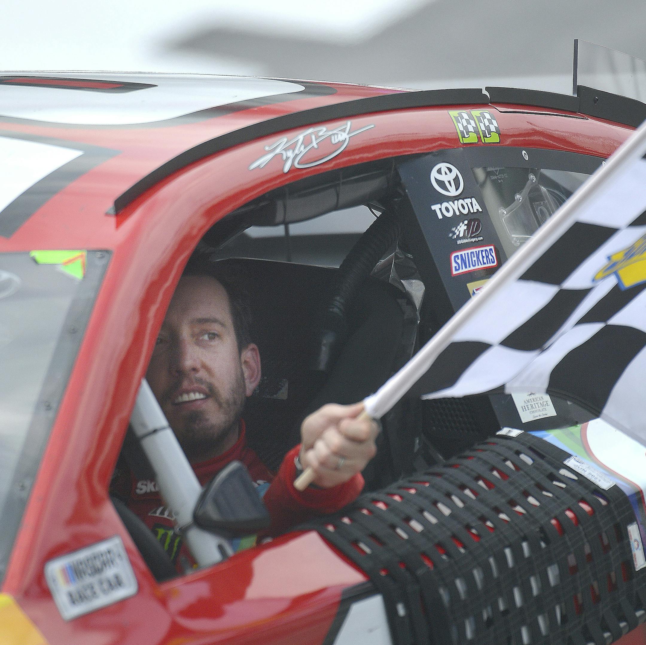 Kyle Busch holds the checkered flag after his win in the NASCAR Cup Series auto race Sunday, April 7, 2019, at Bristol Motor Speedway in Bristol, Tenn. (Andre Teague/Bristol Herald Courier via AP)