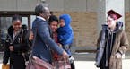 Augsburg Professor Mzenga Aggrey Wanyama embraces his family outside the Immigration and Customs Enforcement's headquarters in Saint Paul after attend