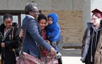 Augsburg Professor Mzenga Aggrey Wanyama embraces his family outside the Immigration and Customs Enforcement's headquarters in Saint Paul after attend