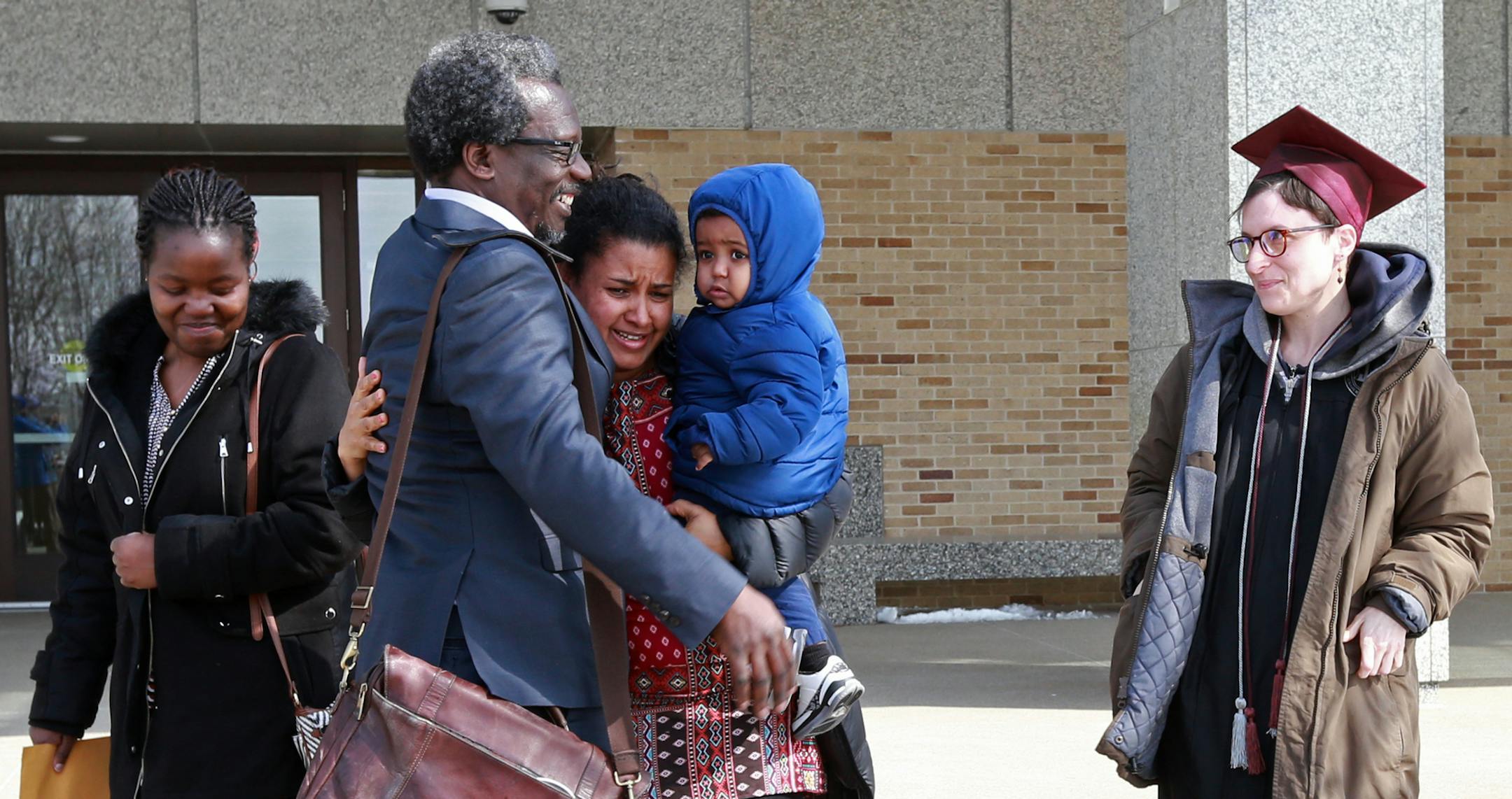 Augsburg Professor Mzenga Aggrey Wanyama embraces his family outside the Immigration and Customs Enforcement's headquarters in Saint Paul after attending a meeting with immigration officials on Friday, March 9, 2018 outside. The professor was greeted by protestors who denounce his deportation to Kenya after living in the United States for 16 years. [Ellen Schmidt ï ellen.schmidt@startribune.com {building is technically Henry Whipple Federal Building
