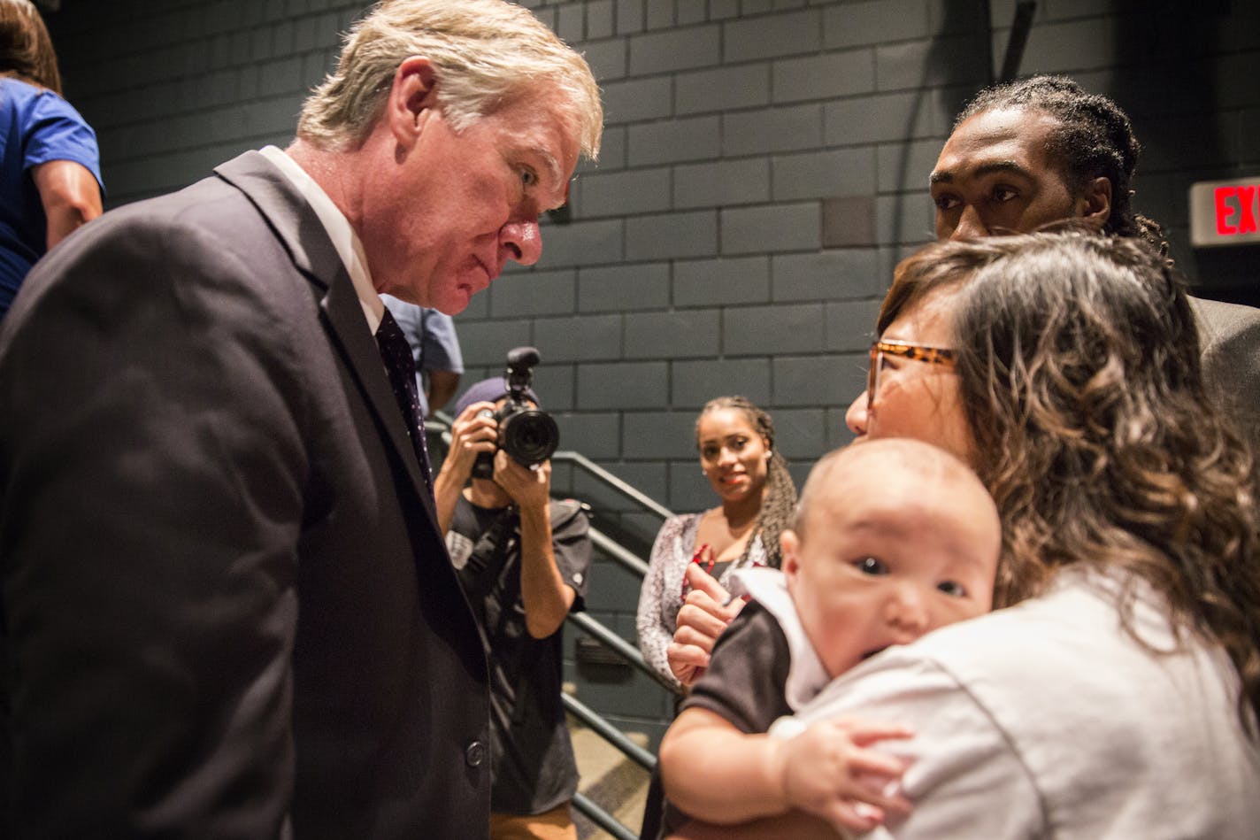 St. Paul Mayor Chris Coleman talks to M.K. Nguyen, holding her 2-month-old son Stokely Phan-Quang, and Maurice Hodges, top right, both residents of the Frogtown neighborhood in St. Paul, after giving his 2016 budget address to the City Council at the Wellstone Center in St. Paul on Tuesday.