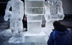 A statue of Jimmy Butler comes to life under the watchful eye of sculptor Sean Leahy who has been carving ice sculptures for 12 years, left, and Jeff 