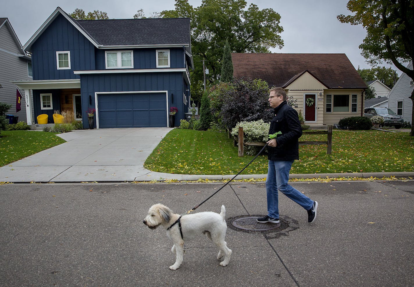 Andy Porter, owner of the building company Refined, walked his dog Hamilton in front of a Refined home to the left, and an older home to the right, in the Pamela Park Neighborhood, Friday, October 5, 2018 in Edina, MN. ] ELIZABETH FLORES &#xef; liz.flores@startribune.com