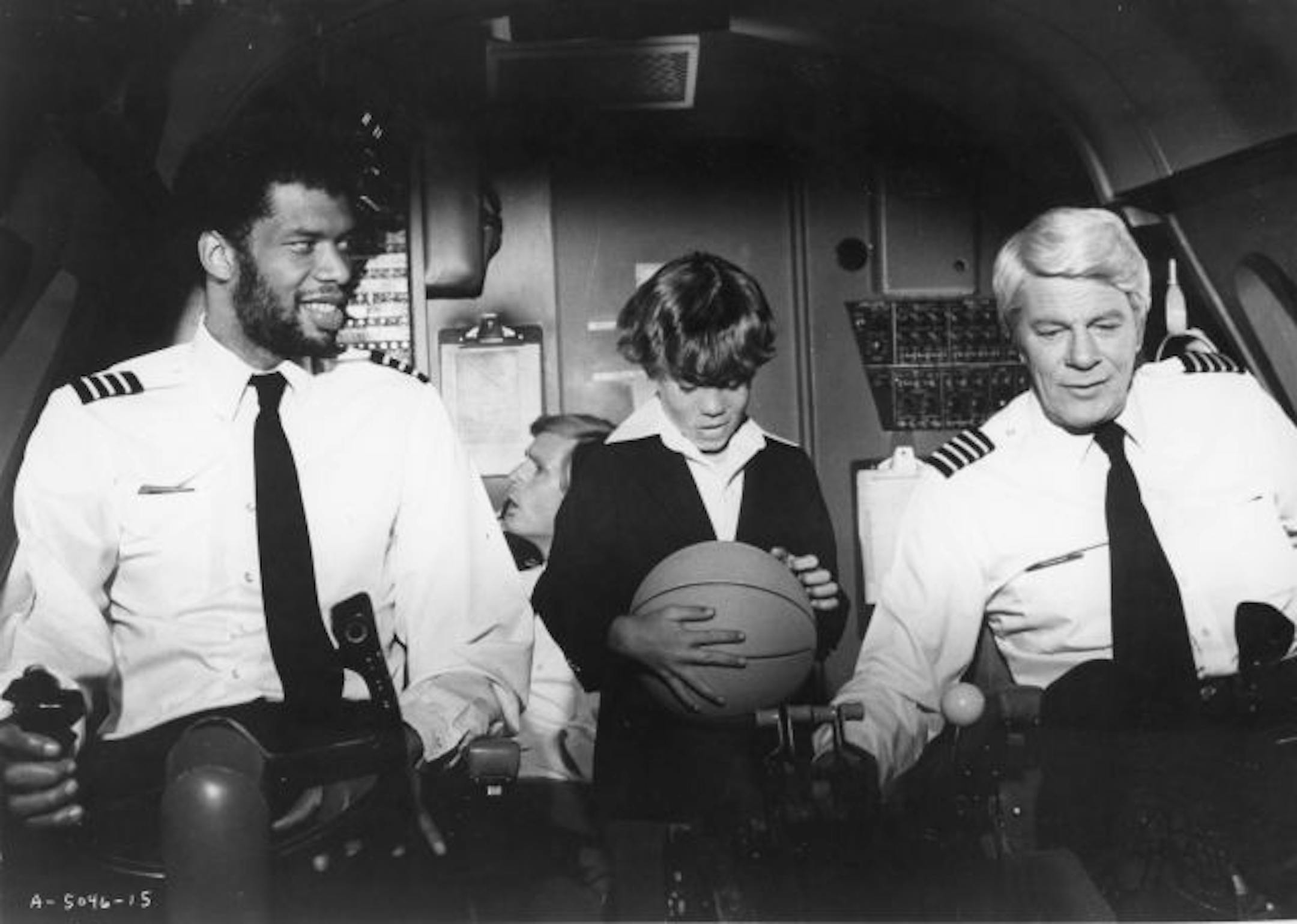 Kareem Abdul-Jabbar, left, and Peter Graves show young Rossie Harris how they check out the controls as Frank Ashmore in the background checks other data in "Airplane!"