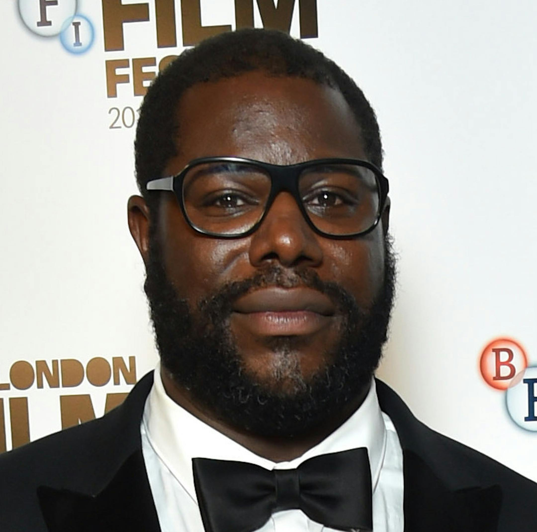 Director Steve McQueen, left, the winner of the BFI Fellowship Award, poses for photographers with presenter Michael Fassbender, in the press room during the London Film Festival Awards, in London, Saturday Oct. 15, 2016. McQueen, a British director and Turner Prize-winning video artist, was presented with the award late Saturday by actor Michael Fassbender, who has appeared in all three of the director's feature films _ "Hunger," `'Shame" and "12 Years a Slave."(Matt Crossick/PA via AP)