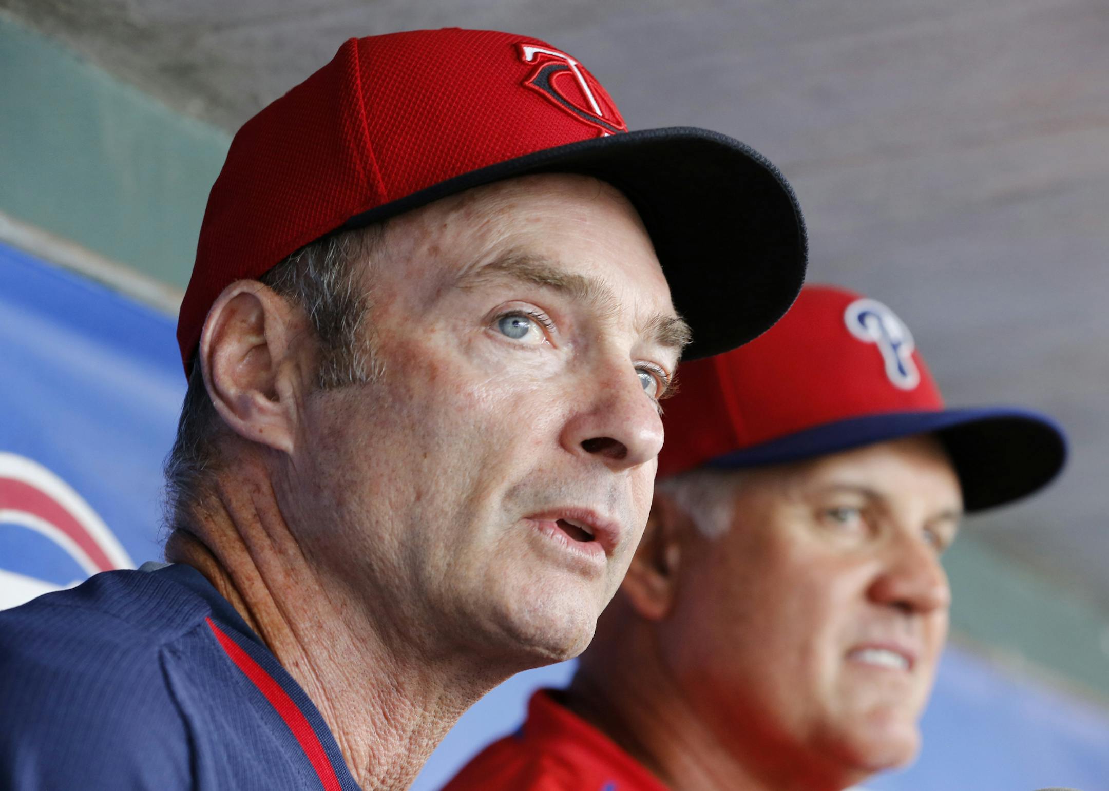 Minnesota Twins manager Paul Molitor, left, and Philadelphia Phillies manager Ryne Sandberg sit in the dugout together before a spring training baseball game between their two teams in Clearwater, Fla., Monday, March 23, 2015. Both managers are Hall of Famers. (AP Photo/Kathy Willens)