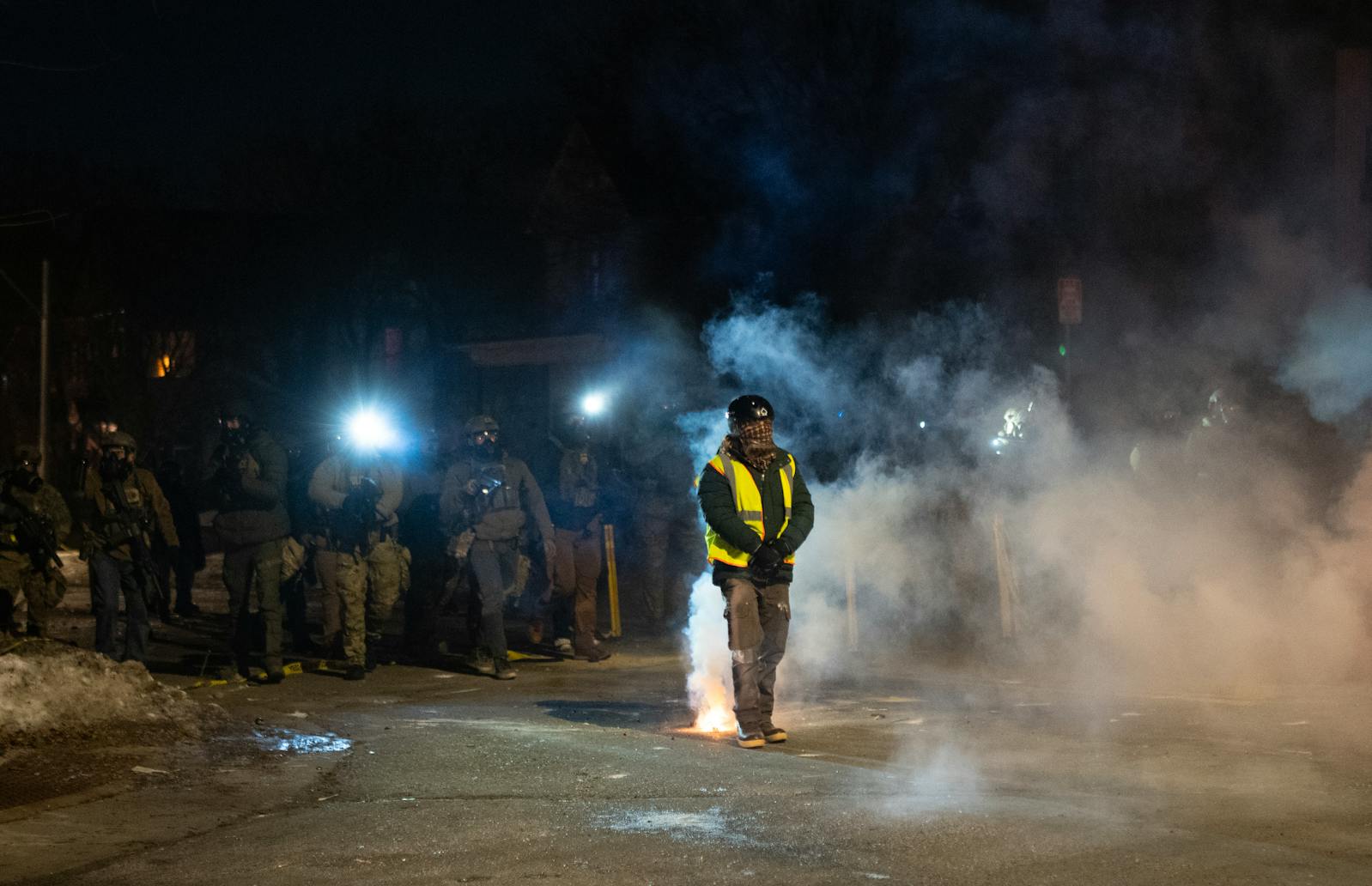 A protester stands their ground as federal officers move to push protesters away from the area, near the scene where a federal agent shot a man in Minneapolis on Wednesday, January 14.